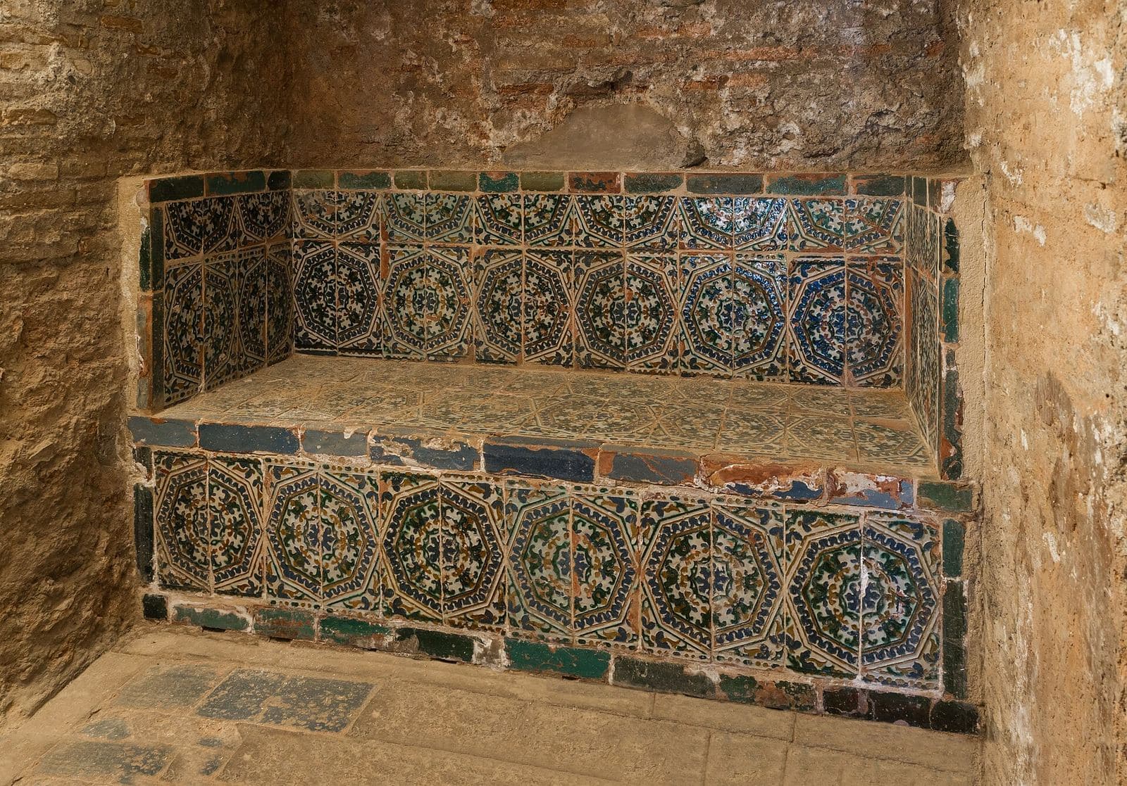 A tiled stone bench in an old bathhouse