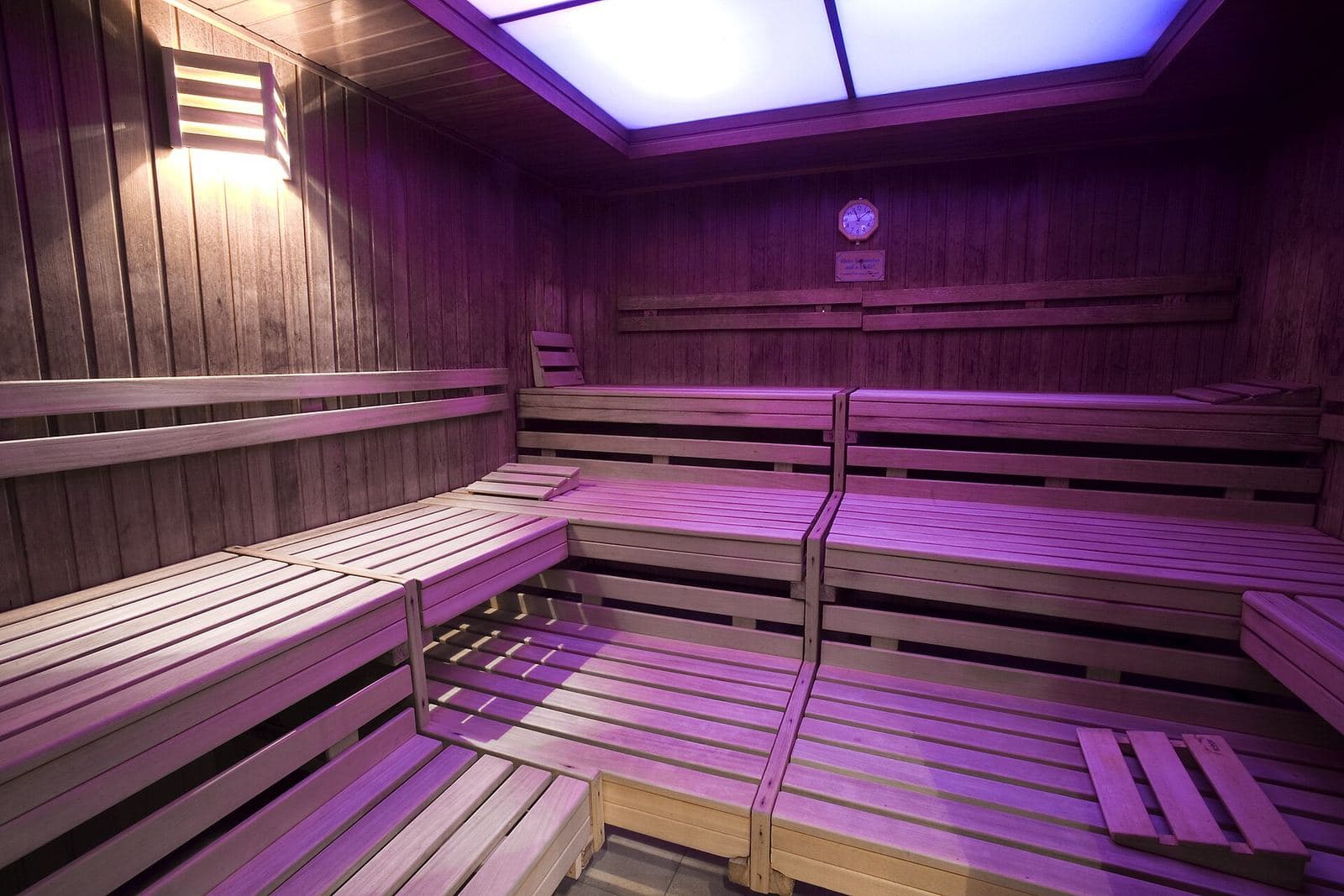 Tiered wooden sauna benches under violet light